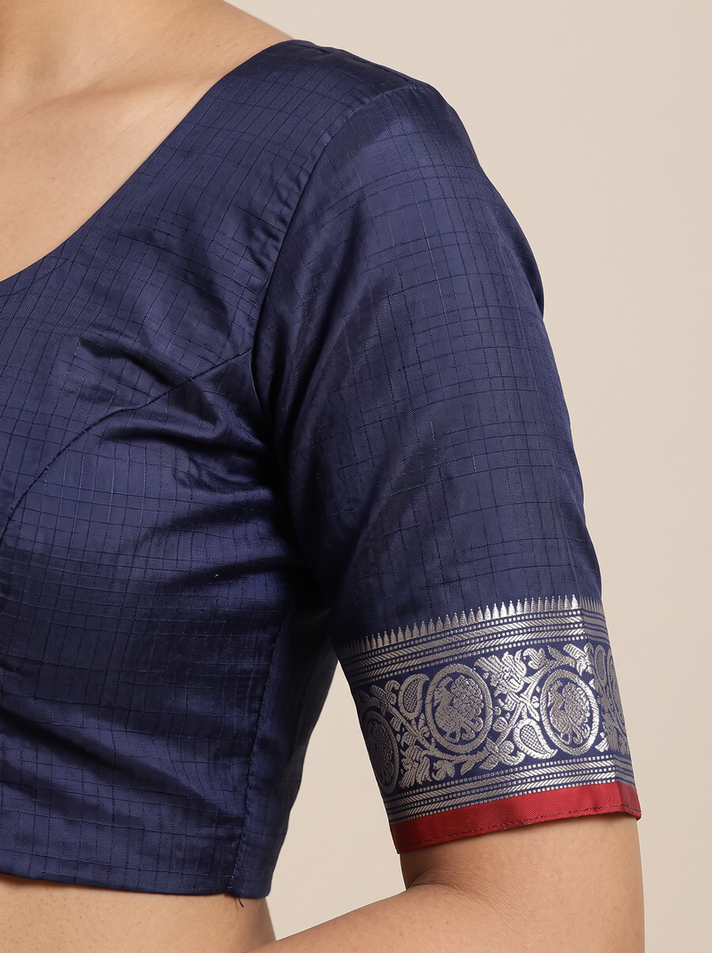 Like a lotus pond under moonlight, sea green silk shimmers with silver butas and fine checks, meeting navy depths and a silver tissue pallu full of zari blossoms. Handloom Gadwal.