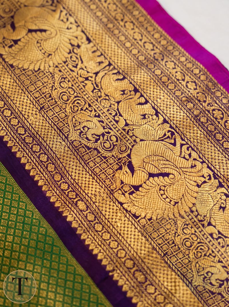 Monsoon green, royal purple, a magenta spark, and peacocks in gold between them. Handloom Gadwal silk.