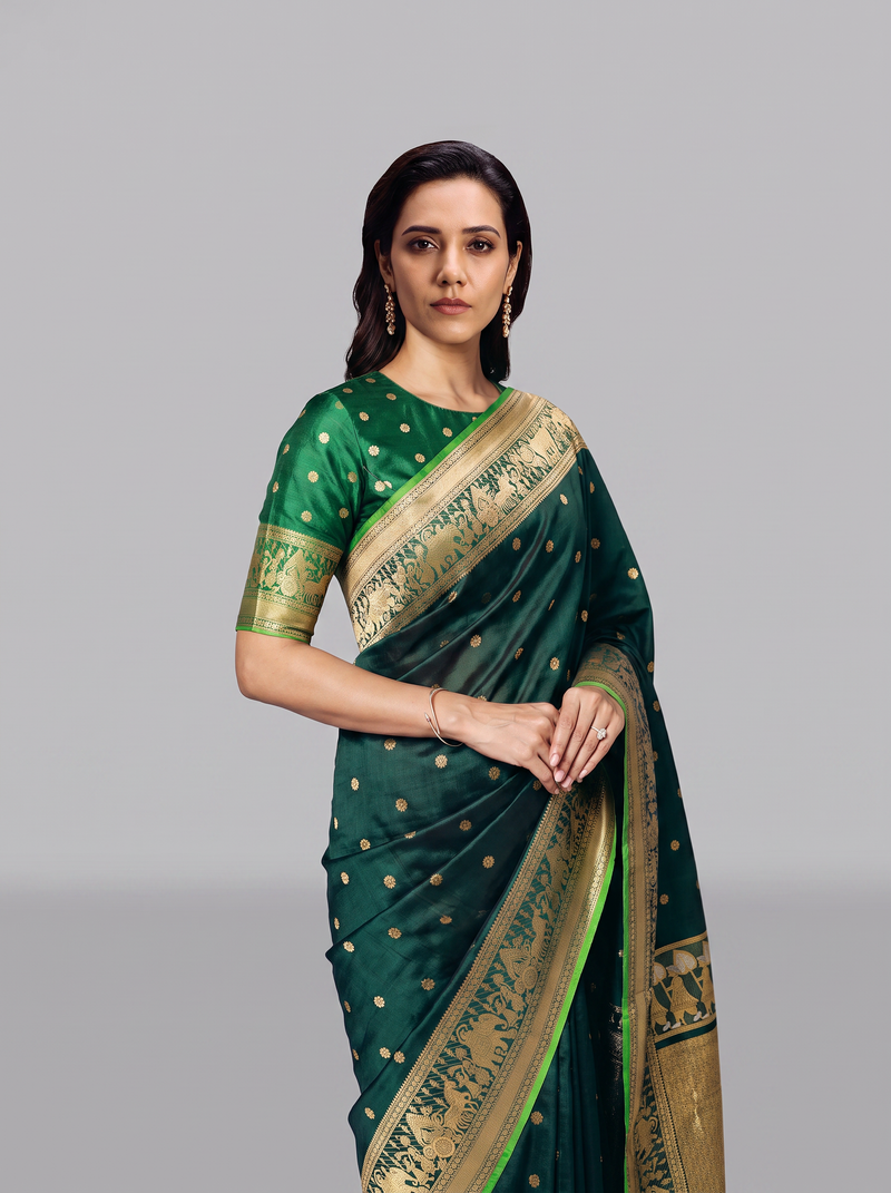 Gadwal - Handloom Gadwal silk in peacock green with tiny gold buttis. Its gold border and pallu glow with ceremonial processions and elephant friezes.