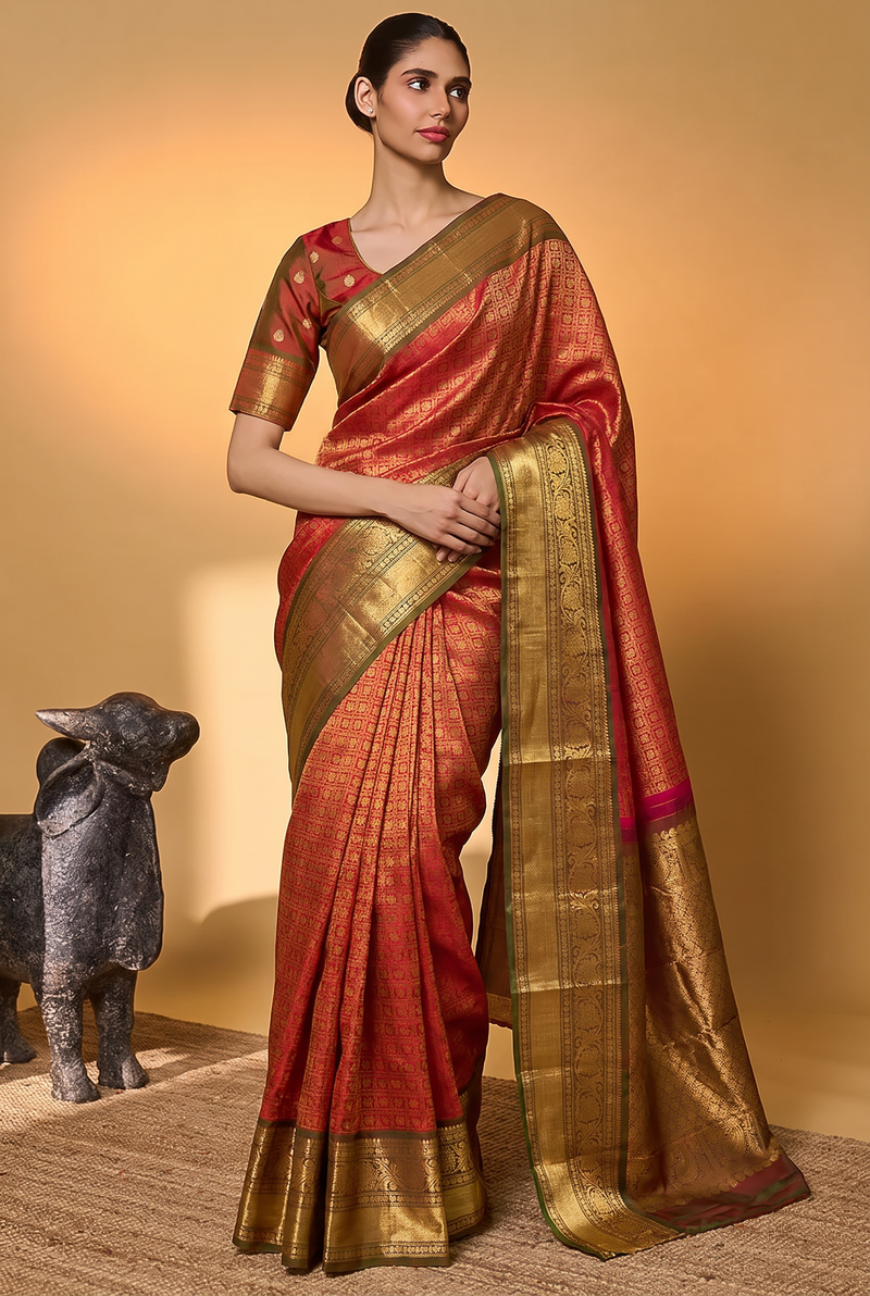 Like a lotus resting on dark leaves, vibrant pink silk glints with gold checks and opens into deep green, where brocade flowers glow in gold. Handloom Gadwal.