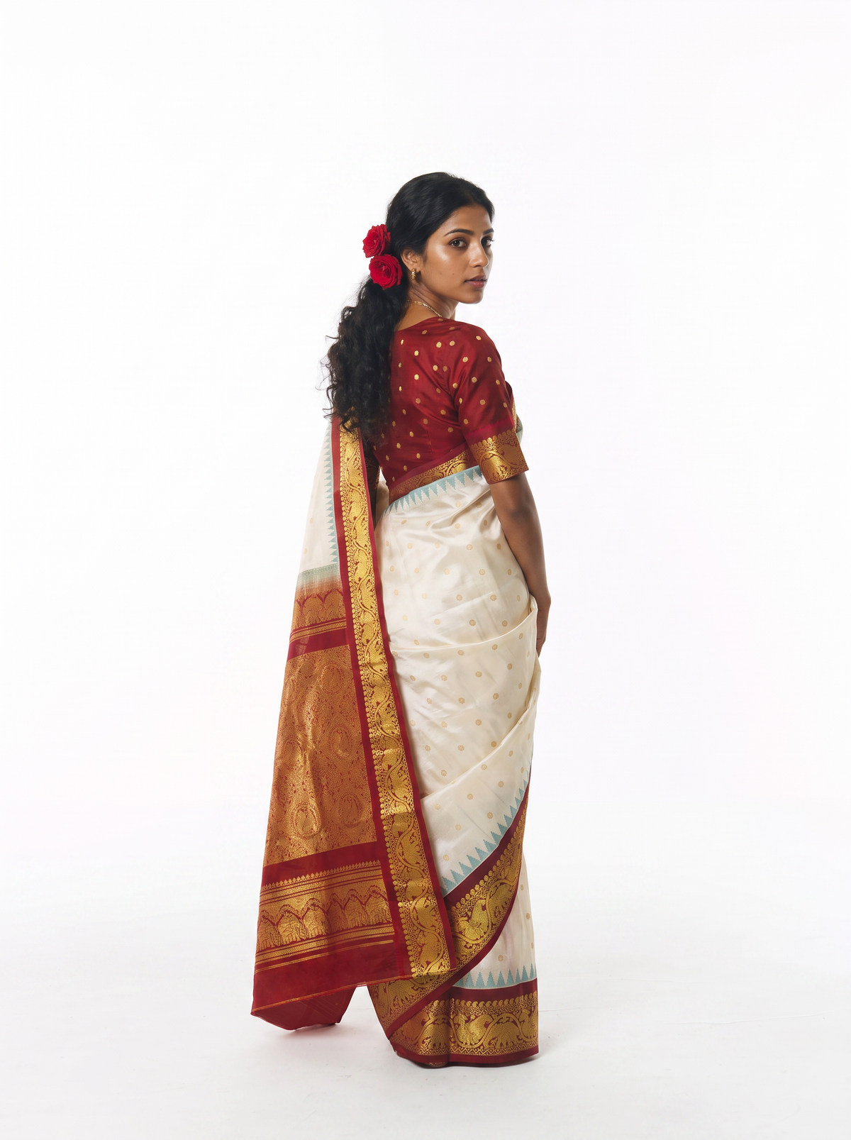 Soft cream scattered with gold, meeting rich maroon where zari elephants march through a golden jaal. Handloom Gadwal silk.