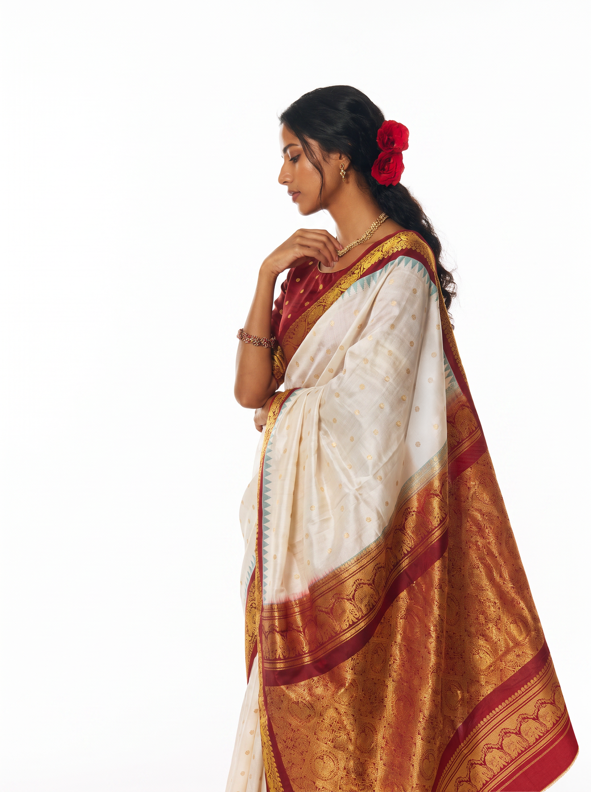 Soft cream scattered with gold, meeting rich maroon where zari elephants march through a golden jaal. Handloom Gadwal silk.
