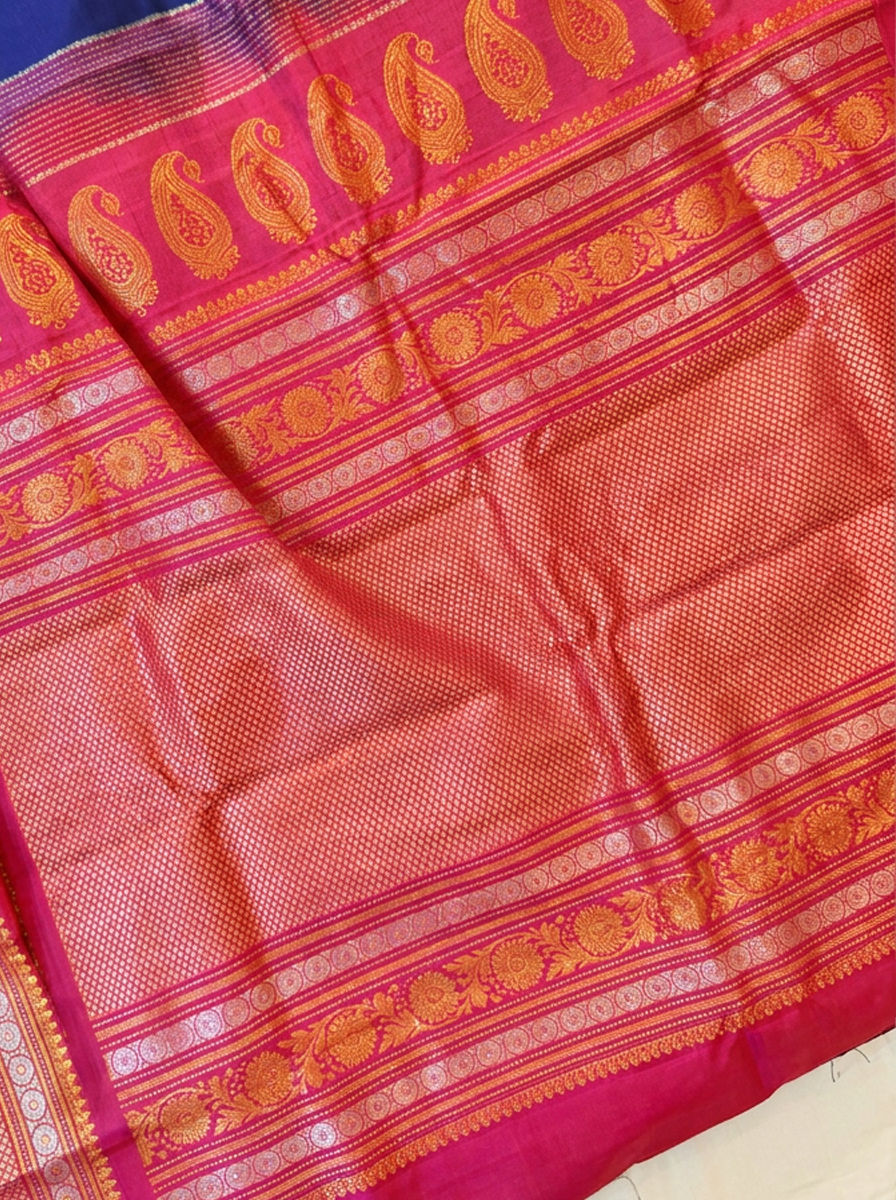 Like sunlight spun into silk, this golden Gadwal blooms with delicate vines, framed by a Kanchi-style border where meenakari medallions and paisleys glow like jewels.