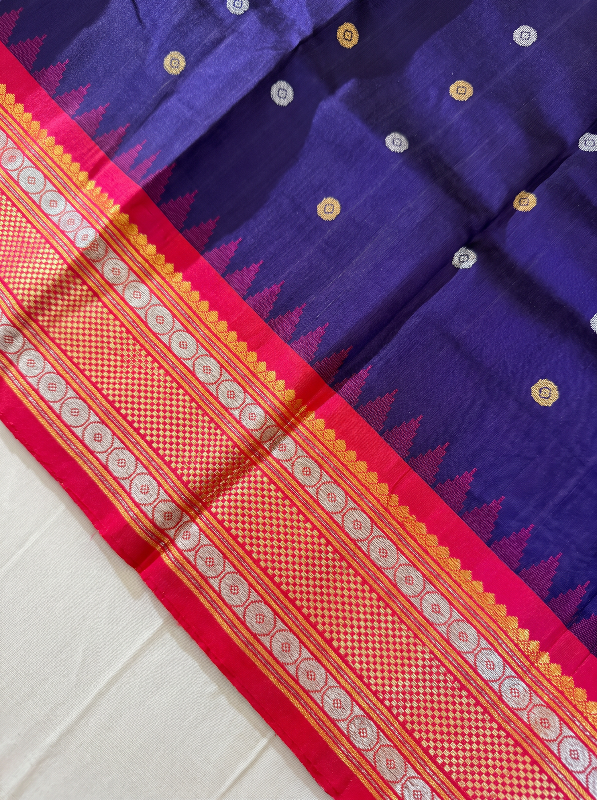 Like sunlight spun into silk, this golden Gadwal blooms with delicate vines, framed by a Kanchi-style border where meenakari medallions and paisleys glow like jewels.
