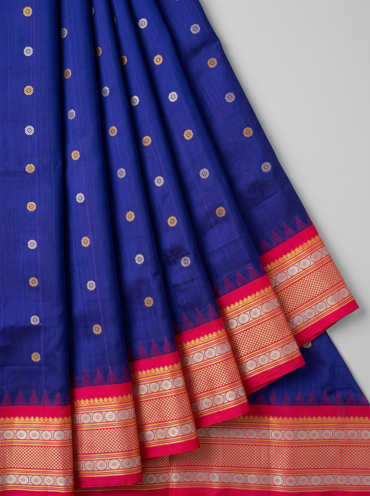 Like sunlight spun into silk, this golden Gadwal blooms with delicate vines, framed by a Kanchi-style border where meenakari medallions and paisleys glow like jewels.