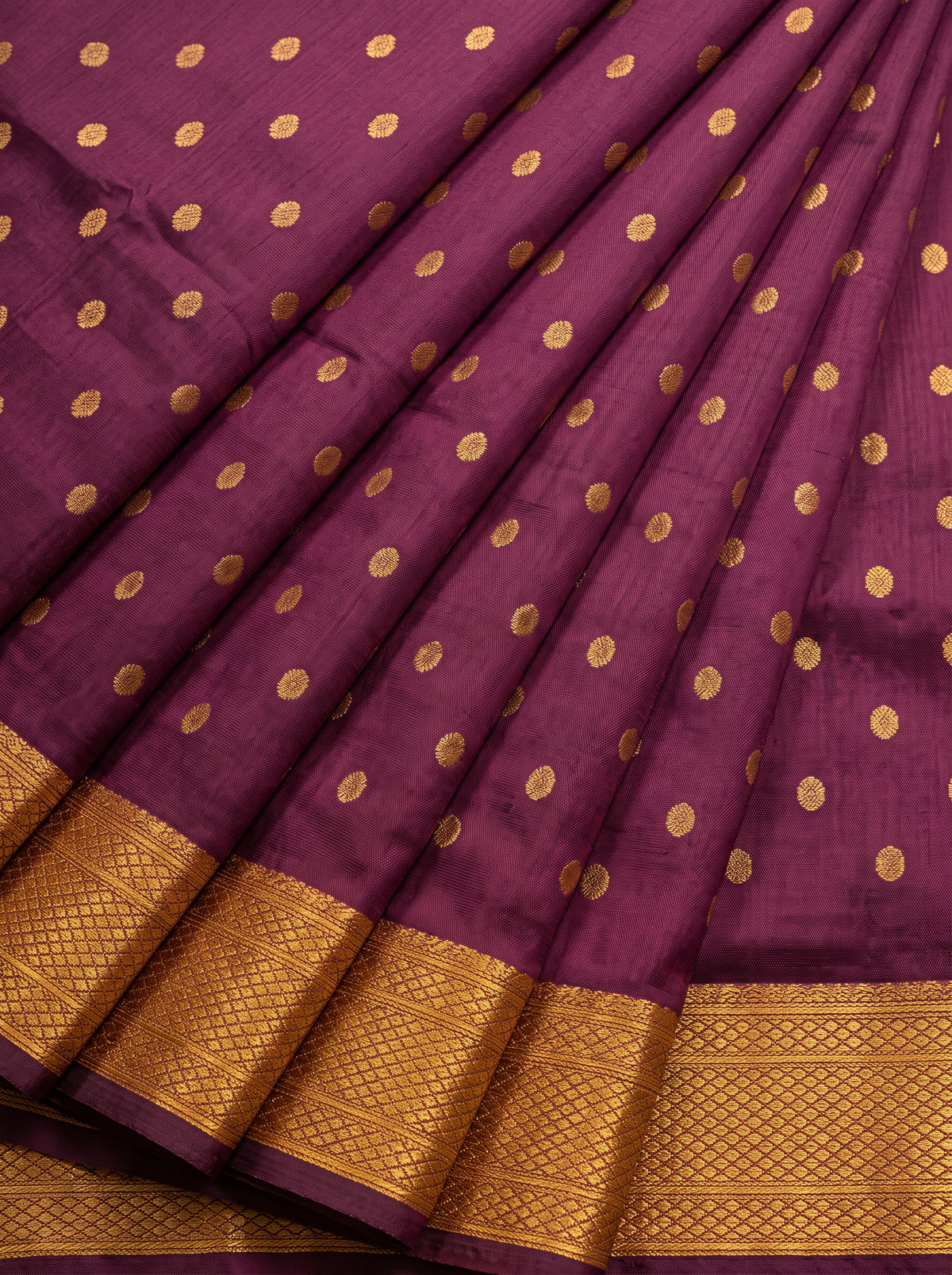 Rich as a first sip of coffee, touched with gold butas and a peacock border. The pallu shines in gold, where pairs of colourful peacocks meet above a violet fringe. Handloom Gadwal silk.