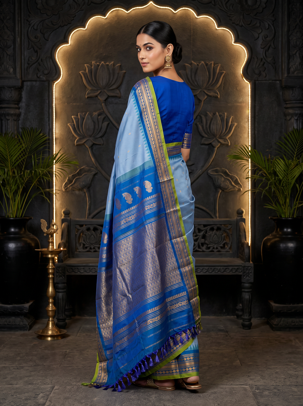 Soft as a morning sky, powder blue silk scattered with gold, deepening into royal blue where zari peacocks rest in a golden jaal. Handloom Gadwal.