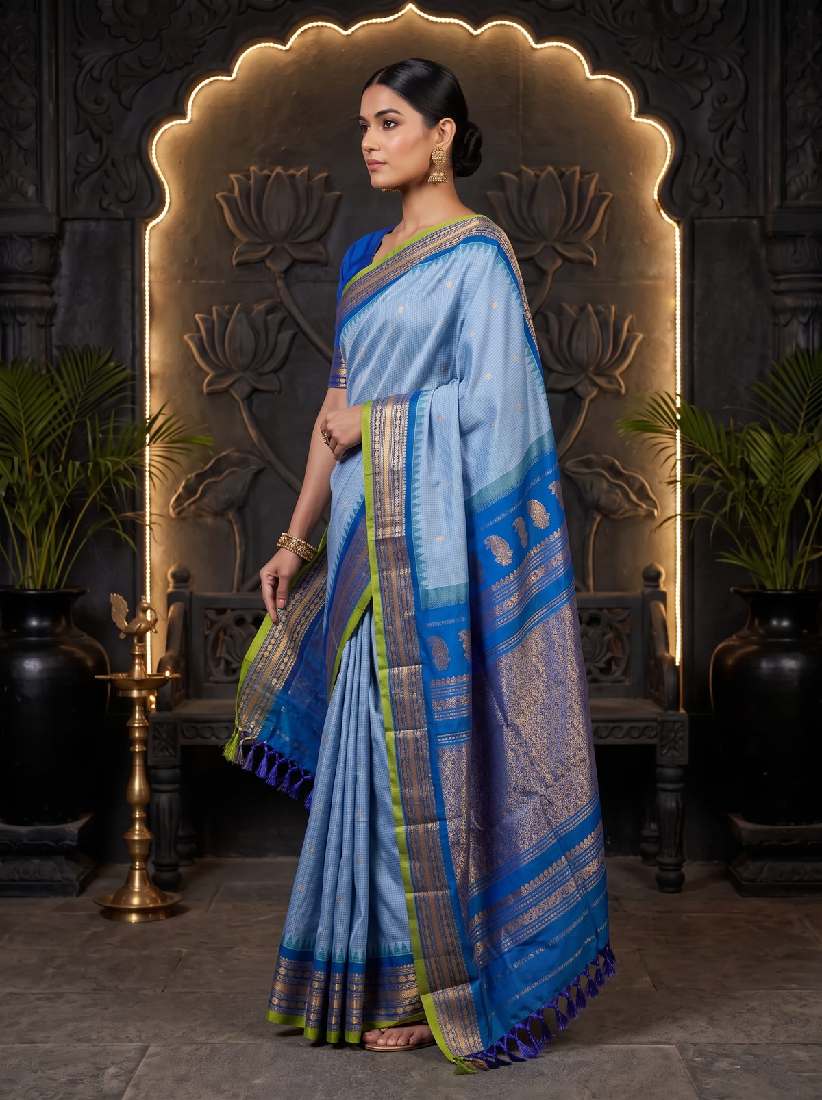 Soft as a morning sky, powder blue silk scattered with gold, deepening into royal blue where zari peacocks rest in a golden jaal. Handloom Gadwal.