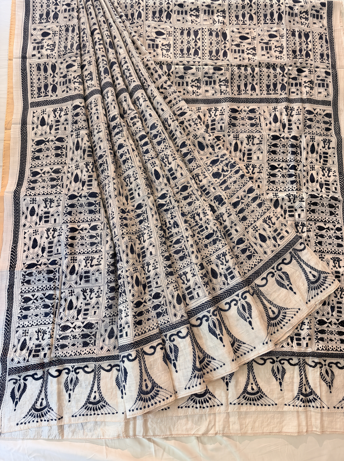 Earthy ivory silk meets the deep drama of black thread. This pure Gachi Tussar carries elaborate hand-stitched Kantha, where light and shadow dance across every fold.