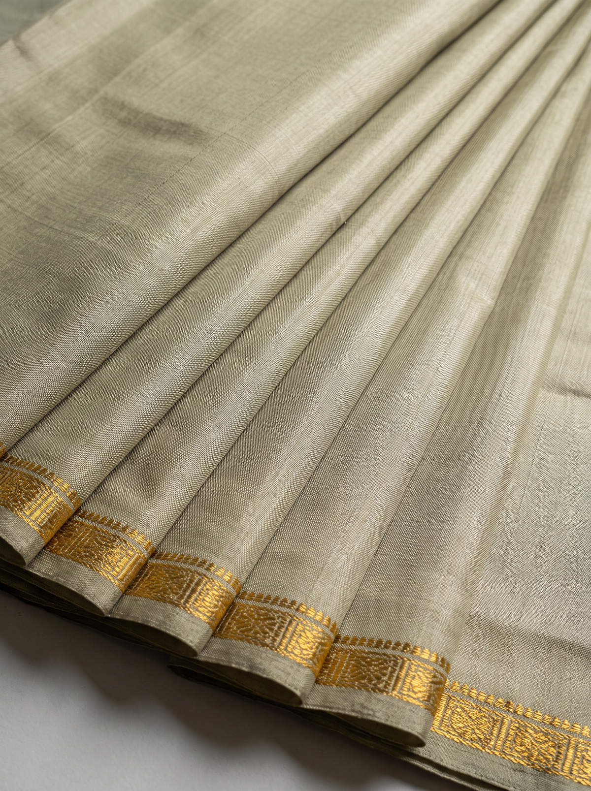 Quiet olive, glorious gold. A pure silk Gadwal with delicate zari borders and a richly woven pallu. Silk Mark certified.