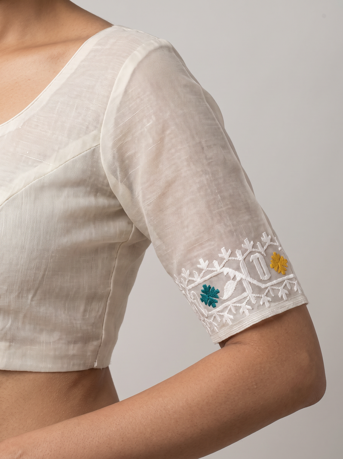 Ivory White Dhakai Jamdani adorned with vibrant Red, Green, and Yellow motifs, delicate white weaving, and subtle multicolored striped accents.