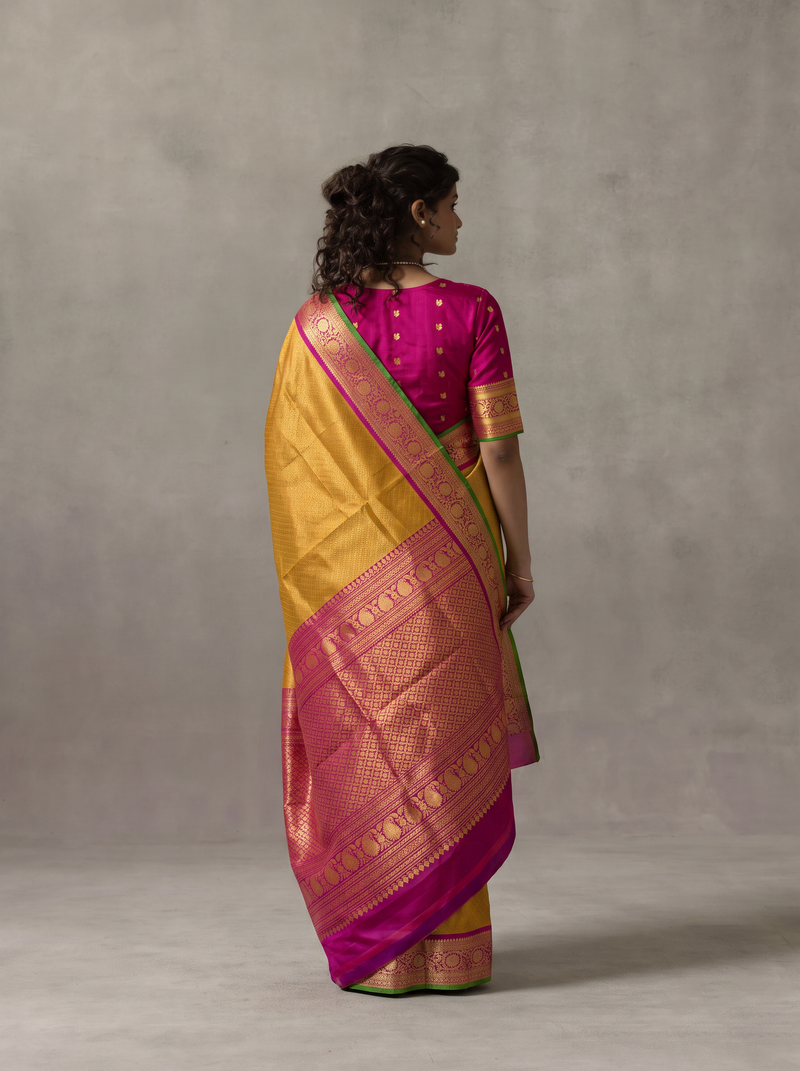 Mustard sunshine, magenta bloom, sacred gold between them. Handloom Gadwal silk.