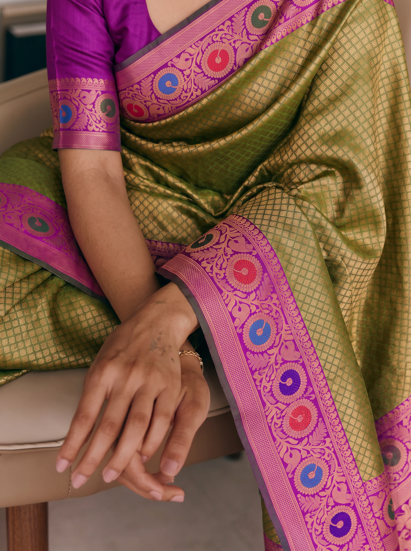 Earthy olive woven with antique gold, meeting regal purple where peacocks strut among paisleys and jewel-toned vines. Handloom Gadwal silk.
