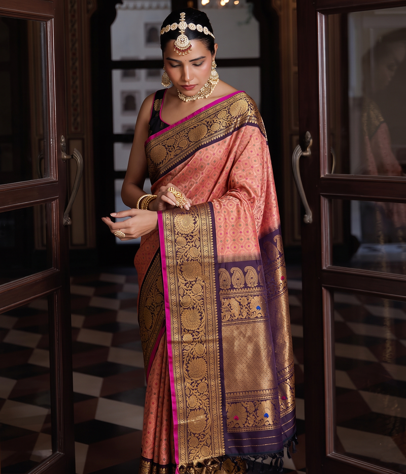 Gadwal -Silk Mark certified handloom Gadwal silk in soft peach diamond brocade with meenakari accents. Its aubergine Kanchi-style border and pallu glow with gold paisleys and meenakari peacocks.