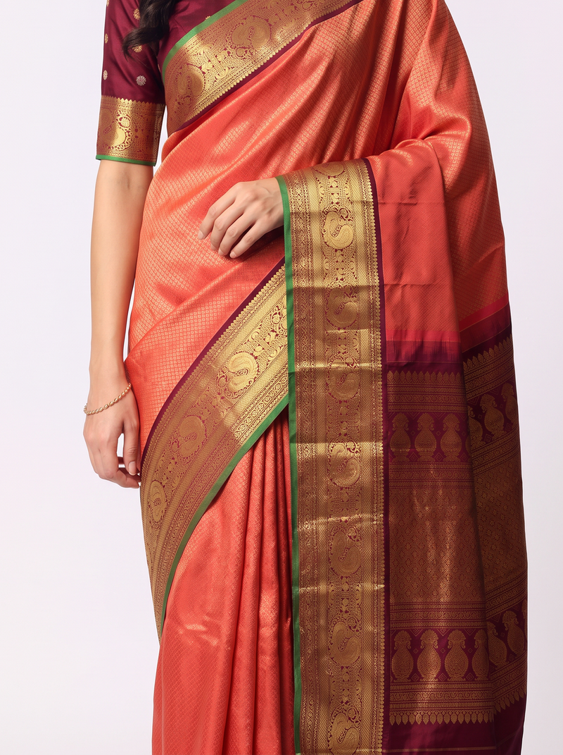 Dawn in peach, dusk in maroon, and peacocks dancing in gold between them. Handloom Gadwal silk.