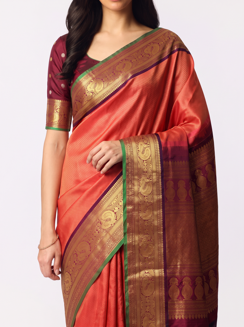 Dawn in peach, dusk in maroon, and peacocks dancing in gold between them. Handloom Gadwal silk.