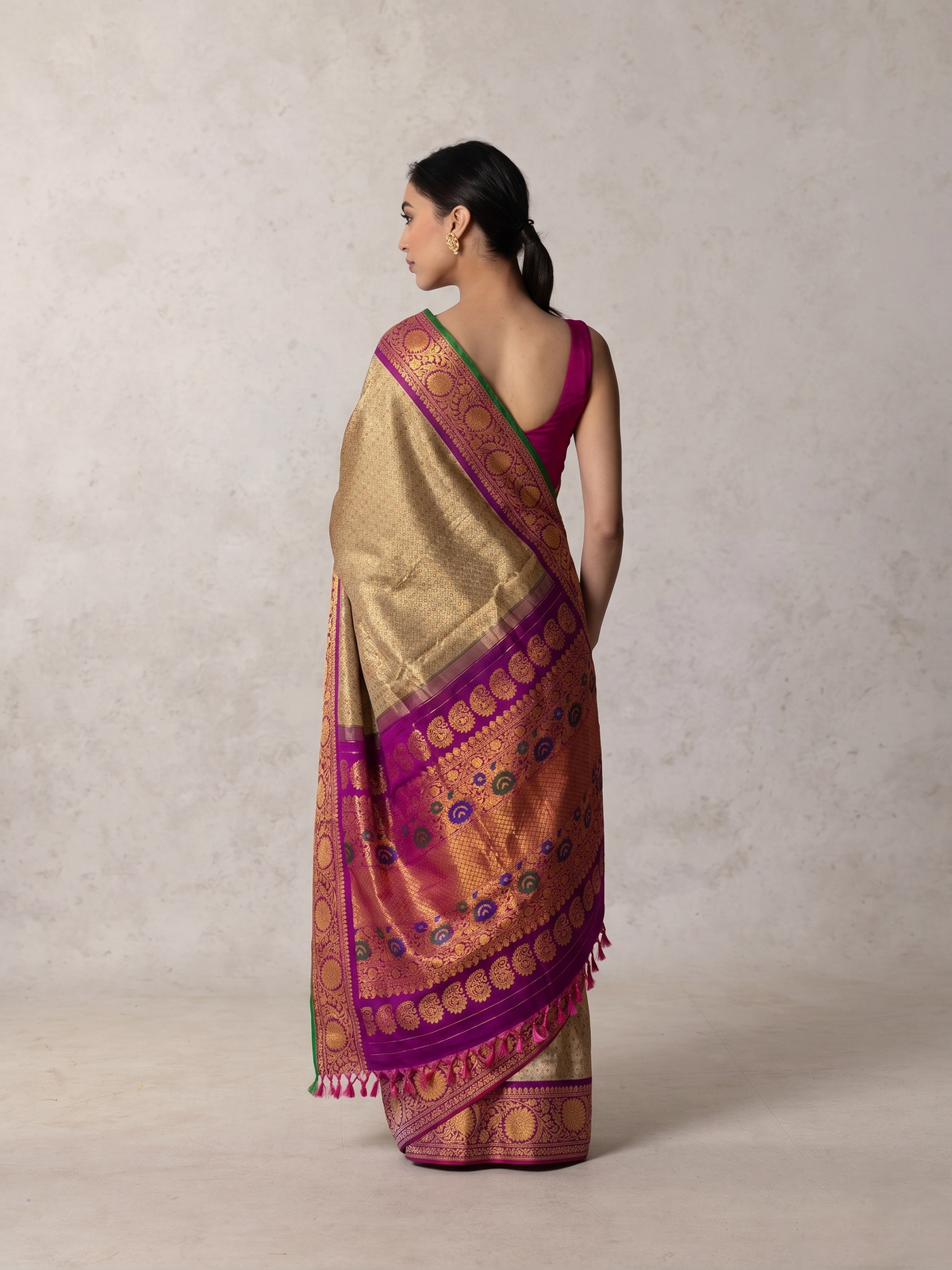 Gold-beige brocade melting into royal purple. A Kanchi-style border strewn with jewel-bright meenakari paisleys. Handwoven Gadwal silk from Telangana, as timeless as the looms that made it.