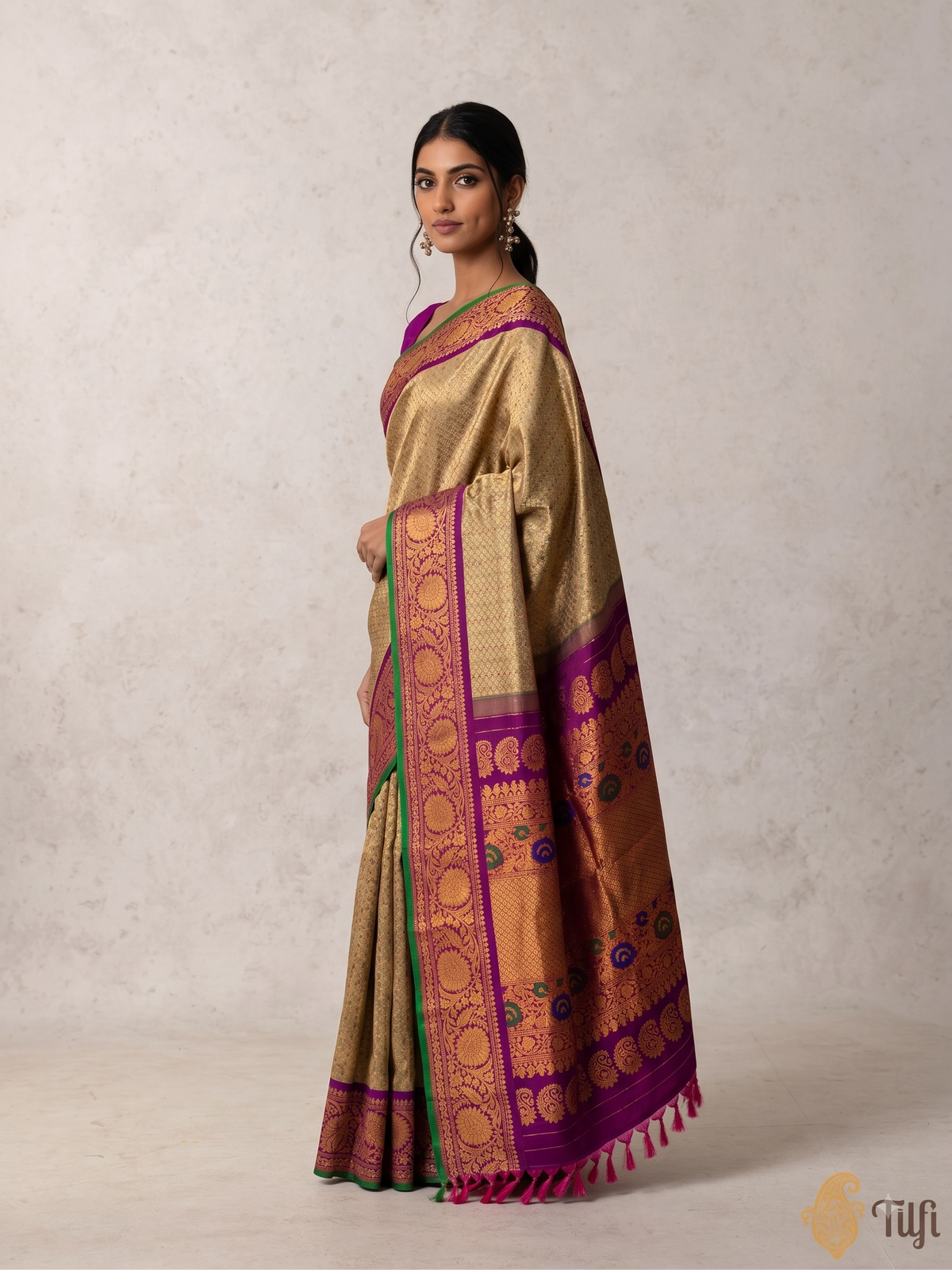 Gold-beige brocade melting into royal purple. A Kanchi-style border strewn with jewel-bright meenakari paisleys. Handwoven Gadwal silk from Telangana, as timeless as the looms that made it.