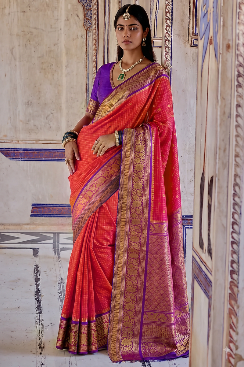 A burst of rani pink, patterned with gold checks and tiny buttis like confetti, held close by deep purple, where a golden jaal shimmers across the border and pallu.