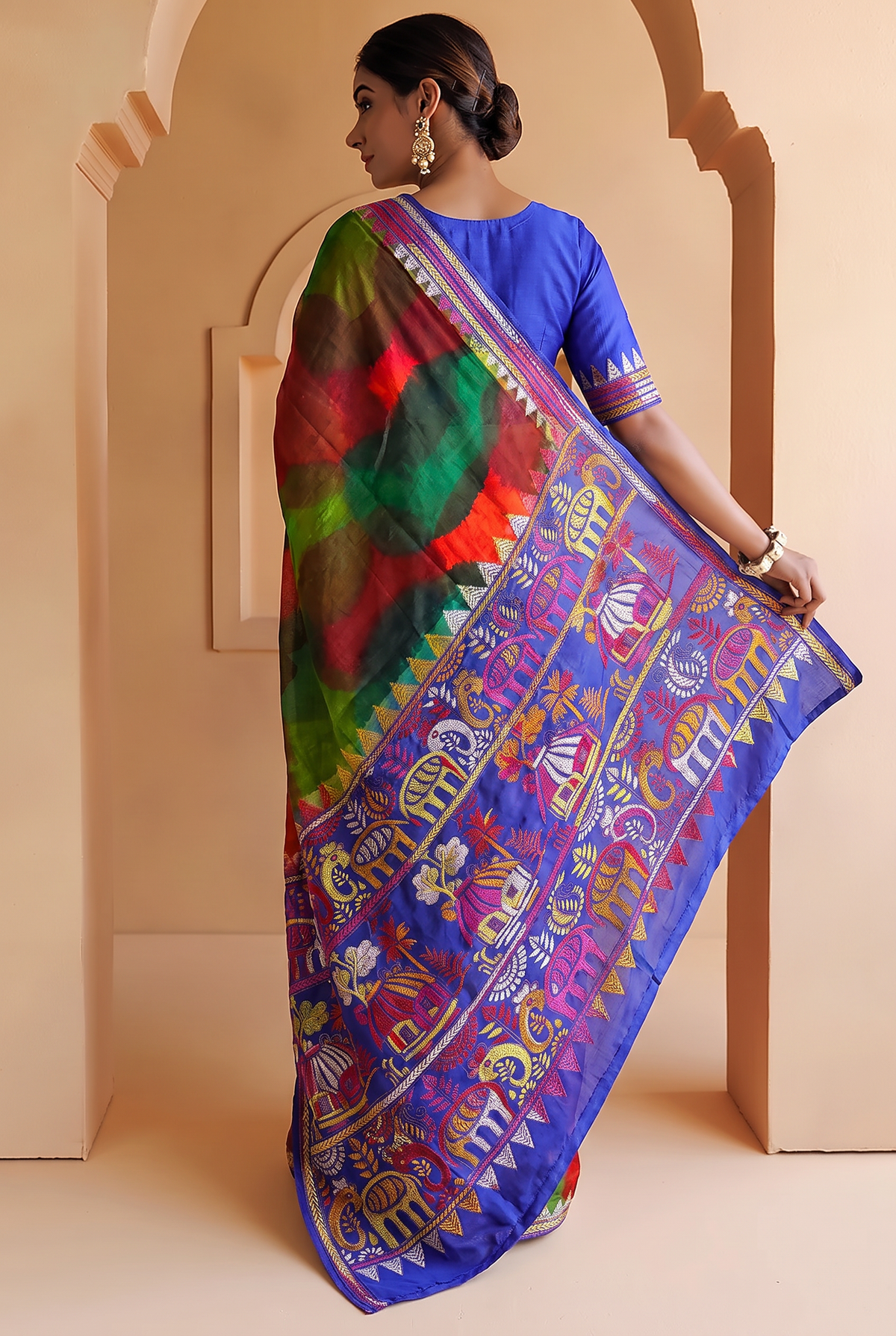 Royal blue silk carrying a love story in every stitch. Elephants sway, peacocks dance and palanquins drift home, until the pallu blushes into a hand-painted wash of red, green and blue.