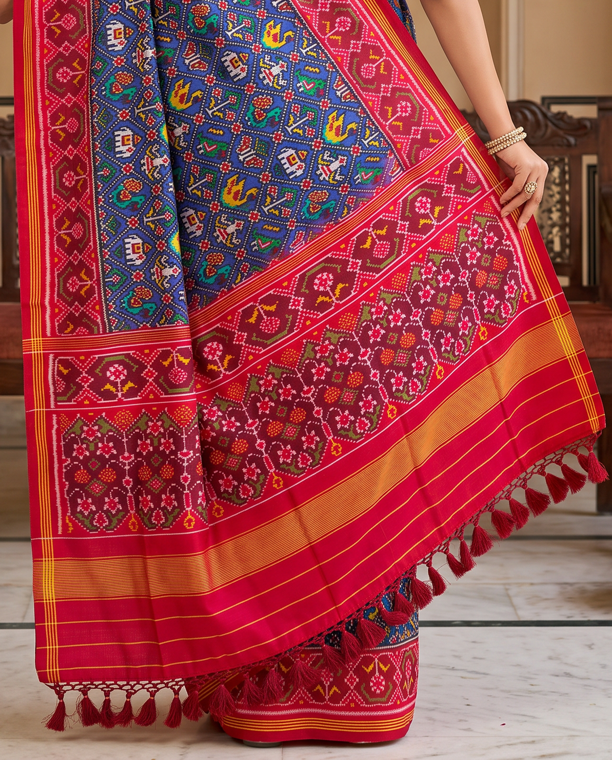 Royal blue, a miniature parade of elephants and peacocks, a red and gold farewell. Handloom Rajkot Patola from Gujarat.