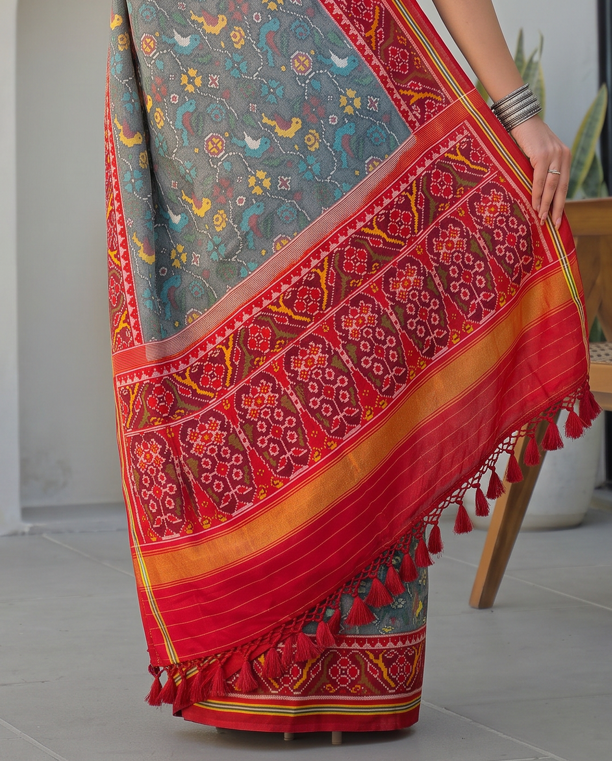 Birds in flight across a grey morning sky, closing in maroon and gold. Silk Mark certified handloom Patola from Gujarat.