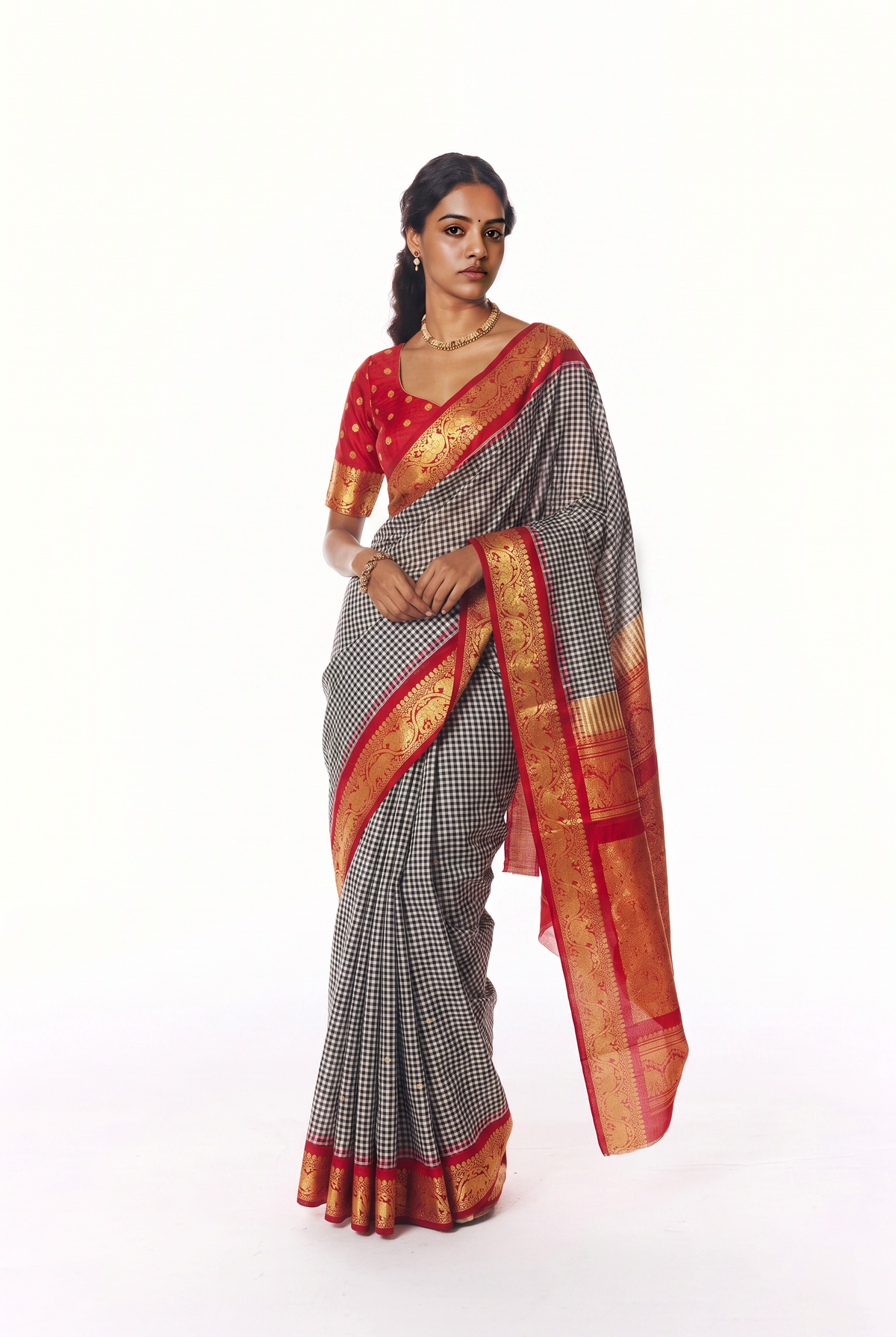 Monochrome checks, a flash of red, and golden elephants and peacocks. Handloom Gadwal silk.