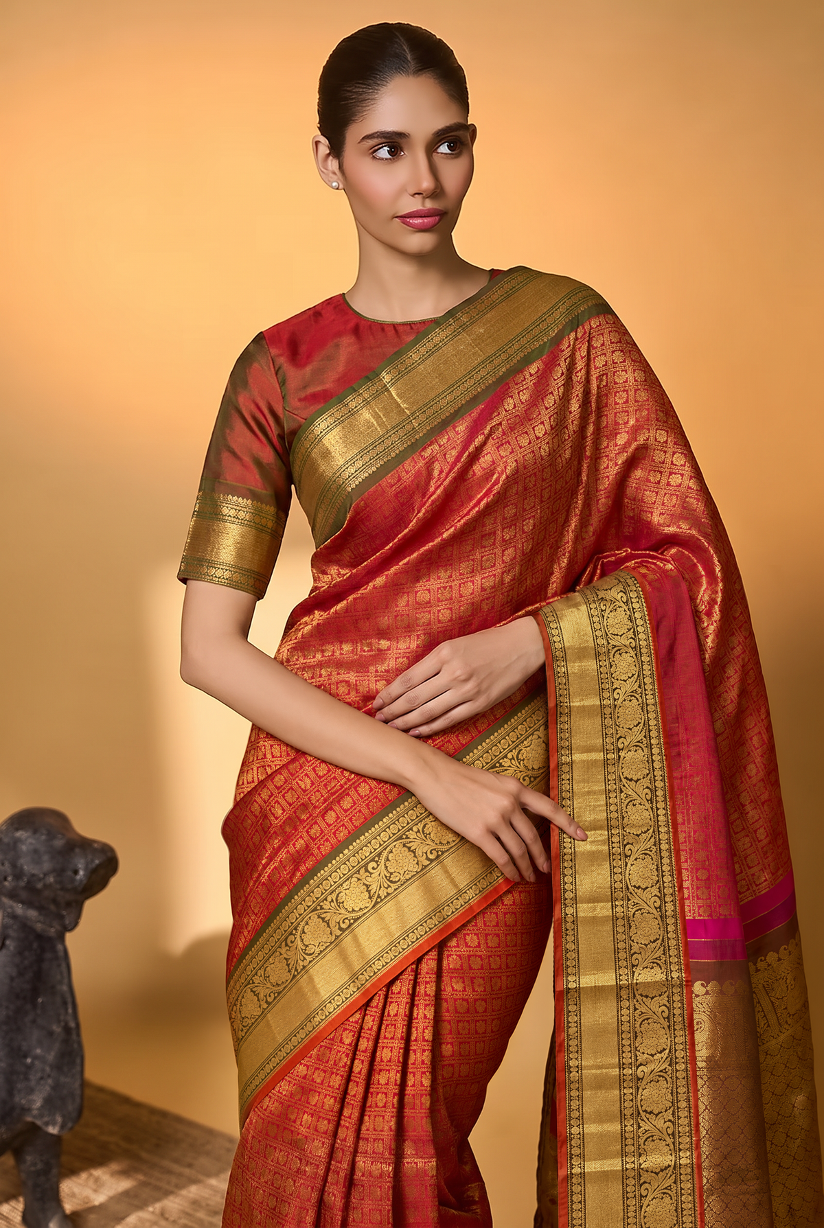 Like a lotus resting on dark leaves, vibrant pink silk glints with gold checks and opens into deep green, where brocade flowers glow in gold. Handloom Gadwal.