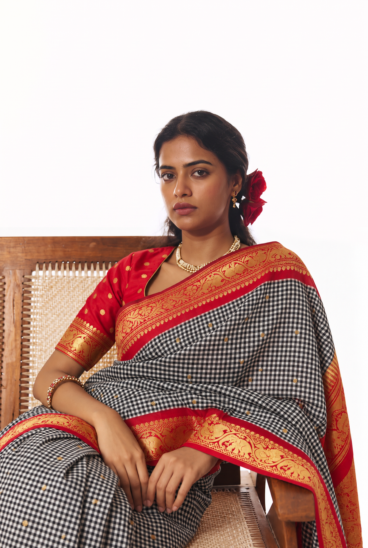 Monochrome checks, a flash of red, and golden elephants and peacocks. Handloom Gadwal silk.